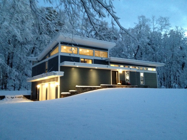 Snow-covered home alight at night