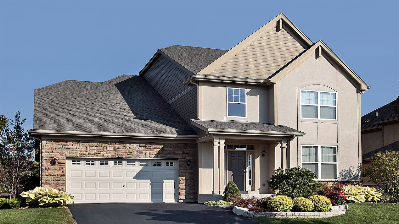 beige home with stone garage