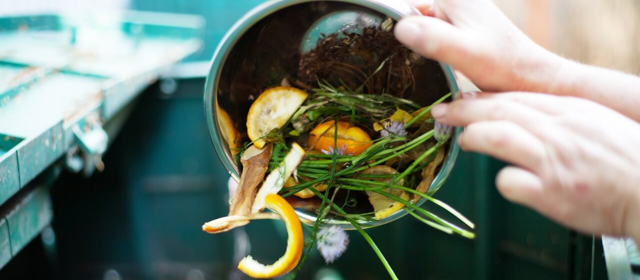 homeowner dropping food scraps in compost