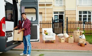 man unloads van outside of his new home