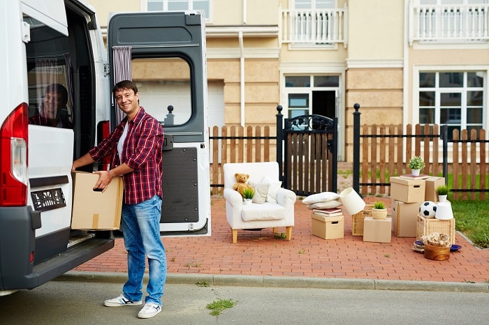 man unloads van outside of his new home
