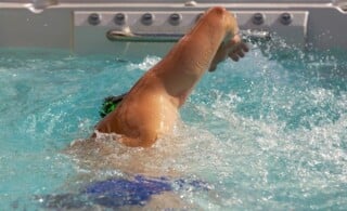 man swimming in endless pool