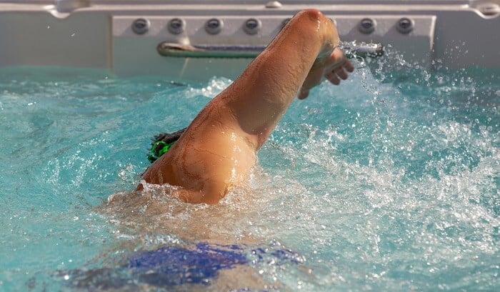 man swimming in endless pool