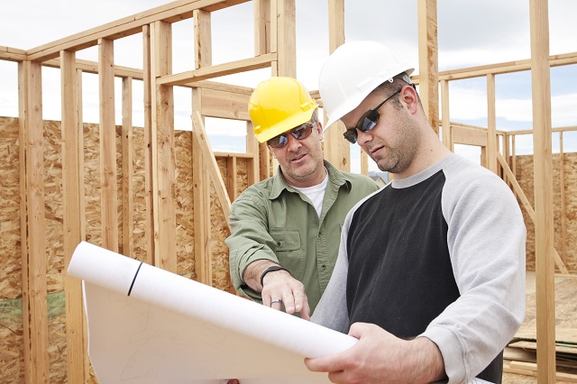Confused construction Contractors deciphering blueprints building a new home