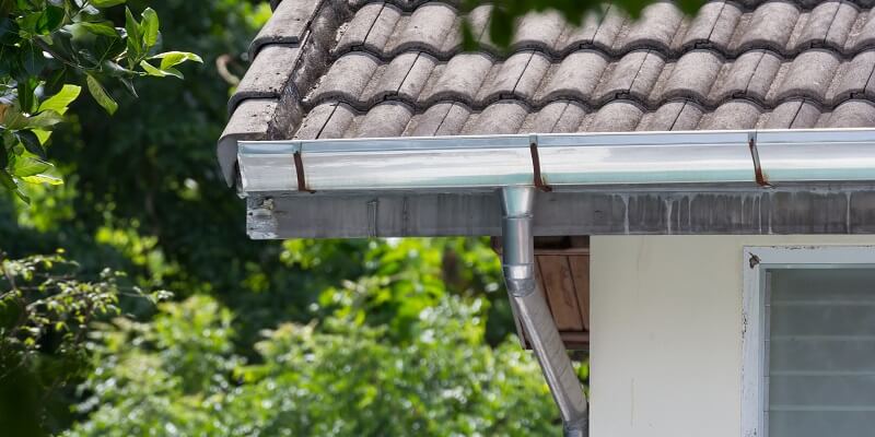 stainless steel gutters on residence with wood shingle roof