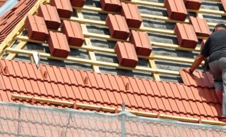 professional roofer installing tiles