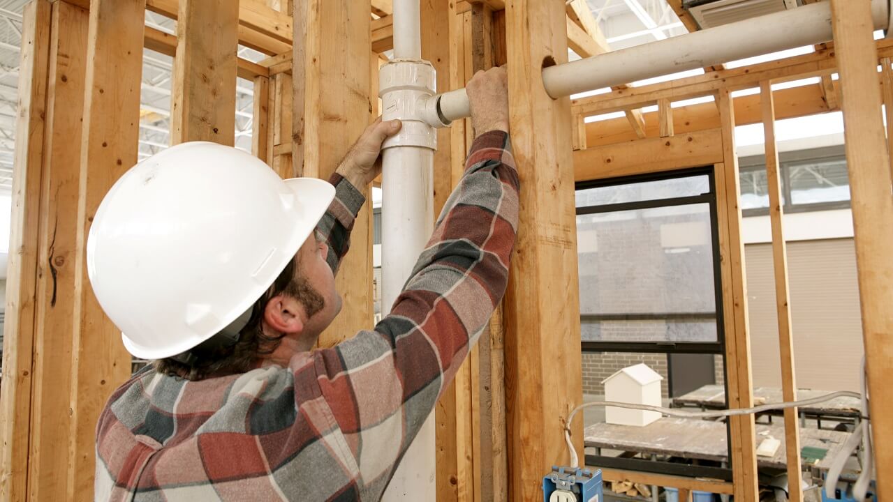 plumber installing pipes in a new build