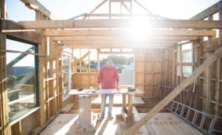 Builder working on framing a house