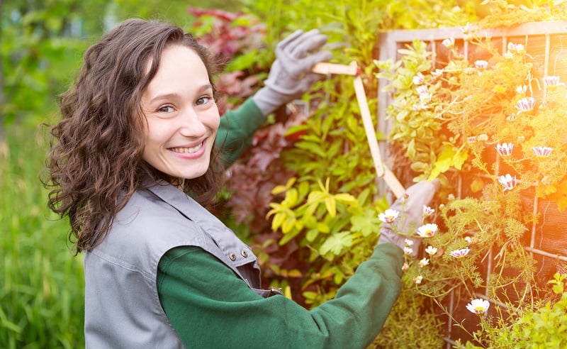 View of a Young attractive landscaper woman working in a yard