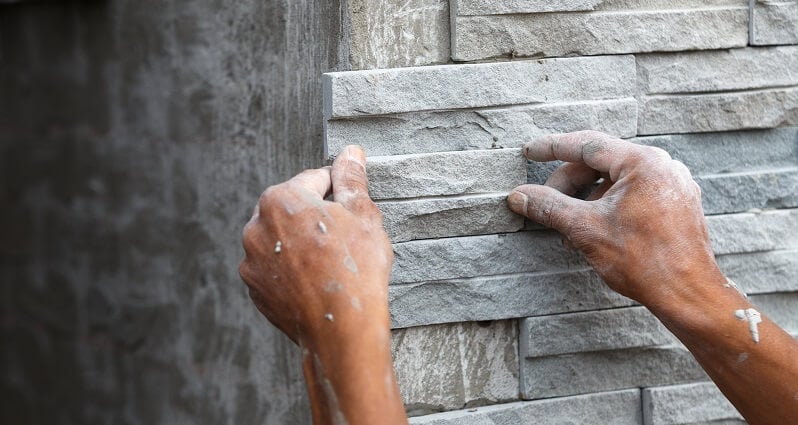 professional installs stone wall