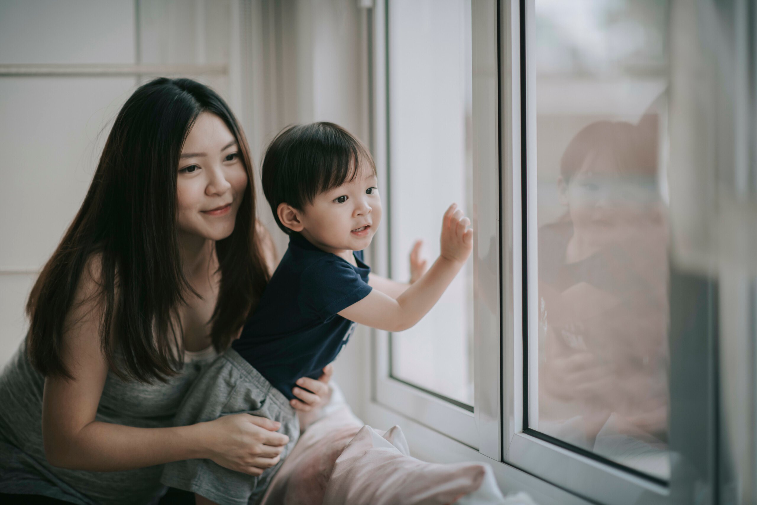 mother and son looking out window