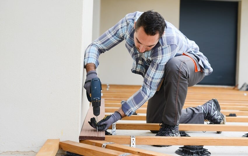 male carpenter begins the foundation for a deck