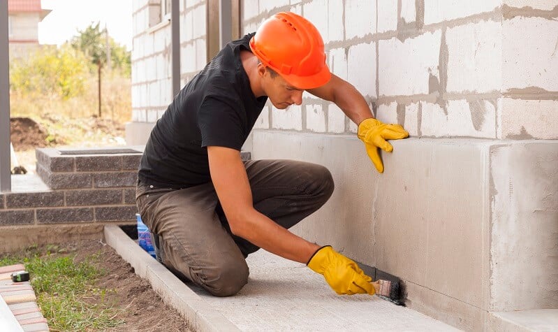 basement waterproofing professional at work