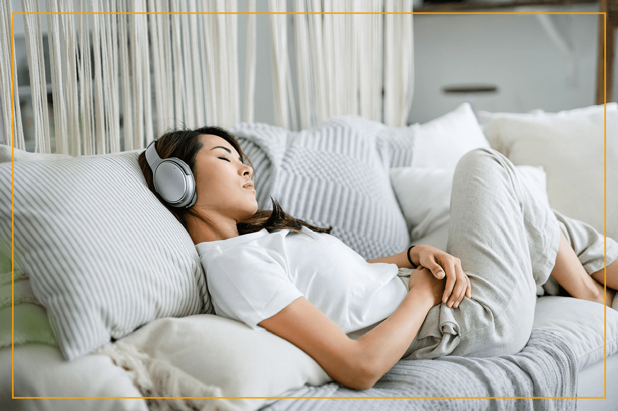 woman relaxed on couch with headphones on