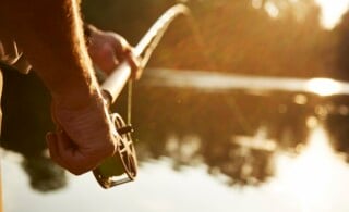 Man fishing in sunny pond