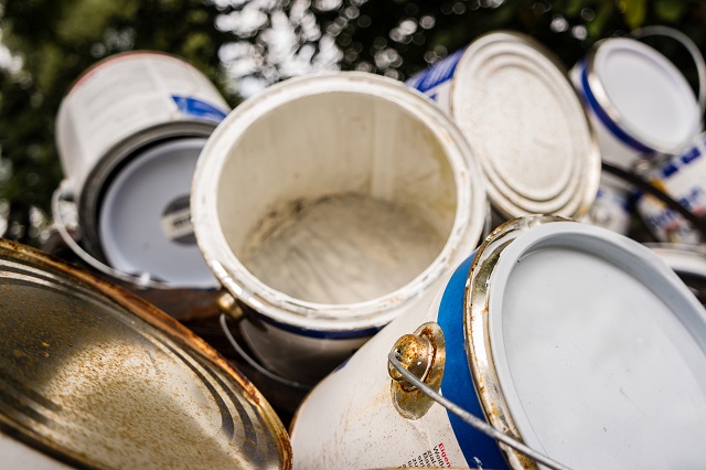 Pile of empty paint cans being disposed