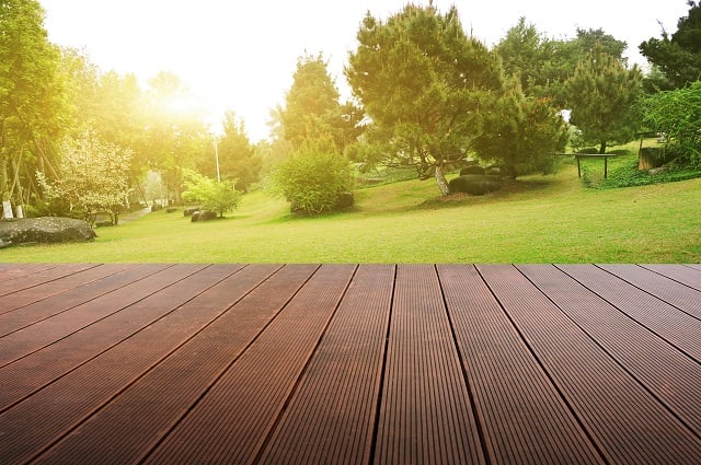 Wooden plank stage platform in a lush backyard