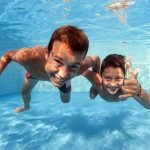 Underwater brothers portrait in swimming pool.