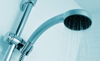 closeup of a height-adjustable shower head pouring water