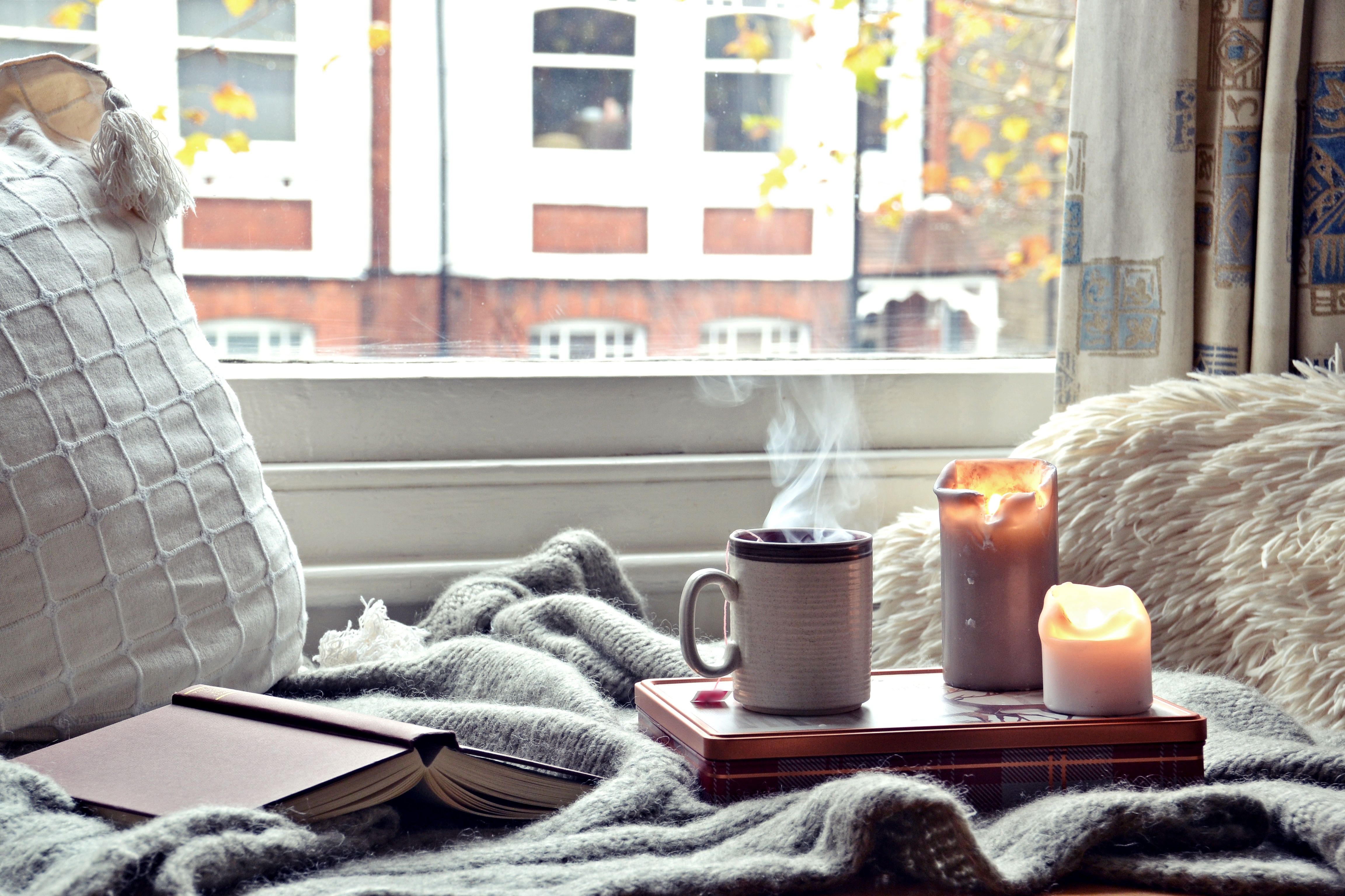 Cozy home. Candles, book and a cup of tea