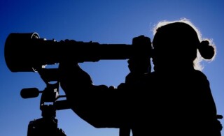 Woman looking through telescope