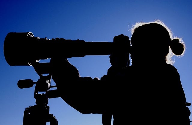 Woman looking through telescope.