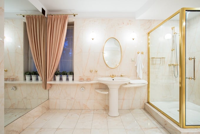 Fancy shower with glass door and golden frame