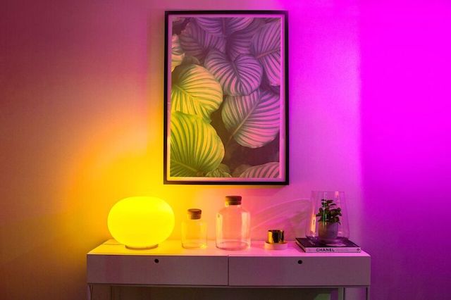 LIFX Smart LED bulb on desk shining vibrant yellow light