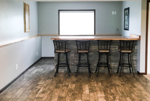 Home bar with stools on reclaimed wood flooring