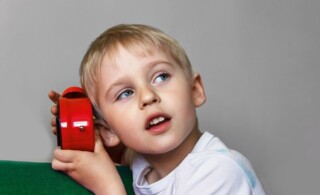 boy investigating the sounds of an alarm clock