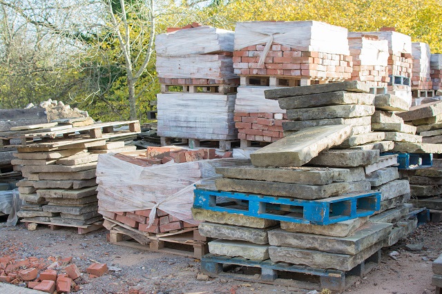 Reclamation yard background: stacks of paving slabs and reclaimed bricks on the pallets