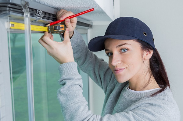 worker measuring widow blinds