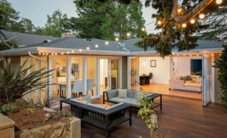 Home with furniture patio / wooden deck at twilight.