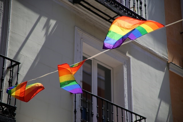 Rainbow flags hanging from the balconies of an old house