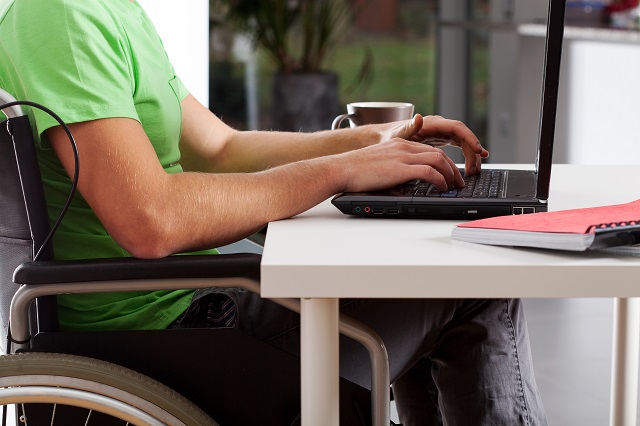 Disabled man writing on laptop