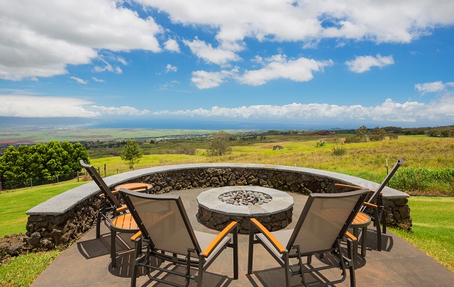 Luxury backyard fire pit surrounded by outdoor seating area and panoramic views