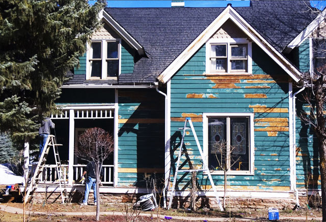 Front of dilapidated home with remodeling equipment in yard