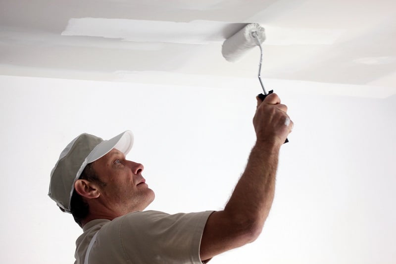 Tradesman painting a ceiling