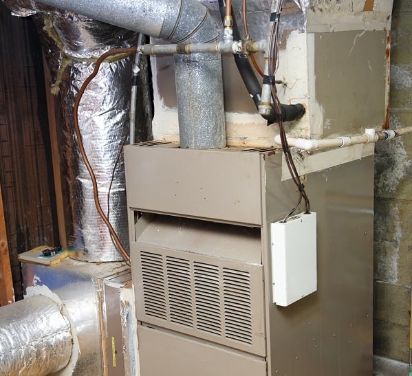 Une vieille chaudière à gaz dans un sous-sol sale.