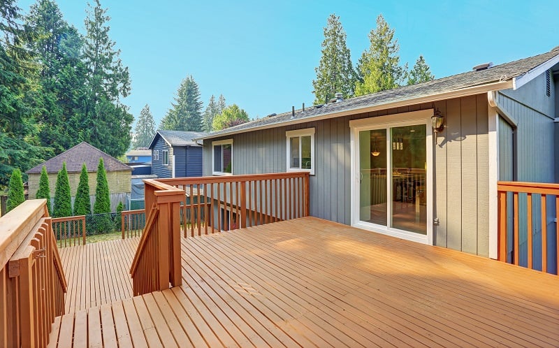 Empty upper level deck boasts redwood railings overlooking the lower level deck.