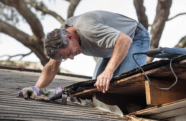 man inspects and repairs a roof