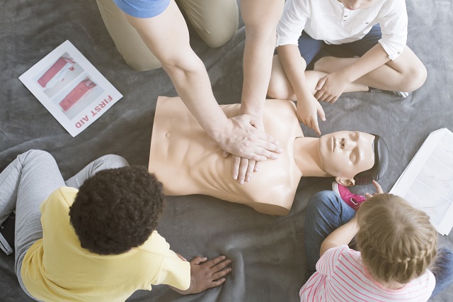 Young children being taught CPR by a trained professional