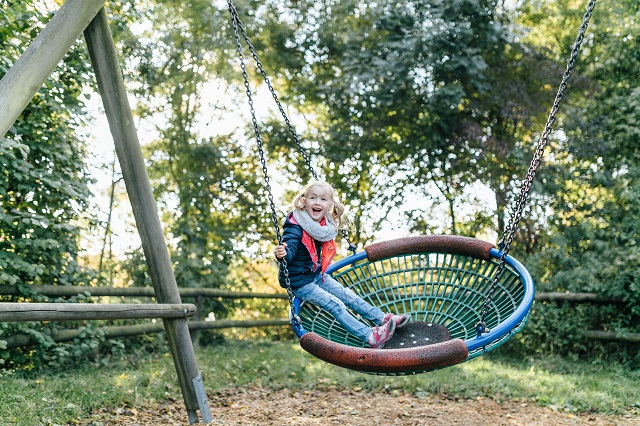 Girl Swinging At Playground