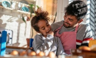 Dad and daughter baking together in the kitchen.