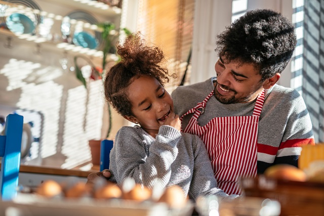 Dad and daughter baking together in the kitchen.