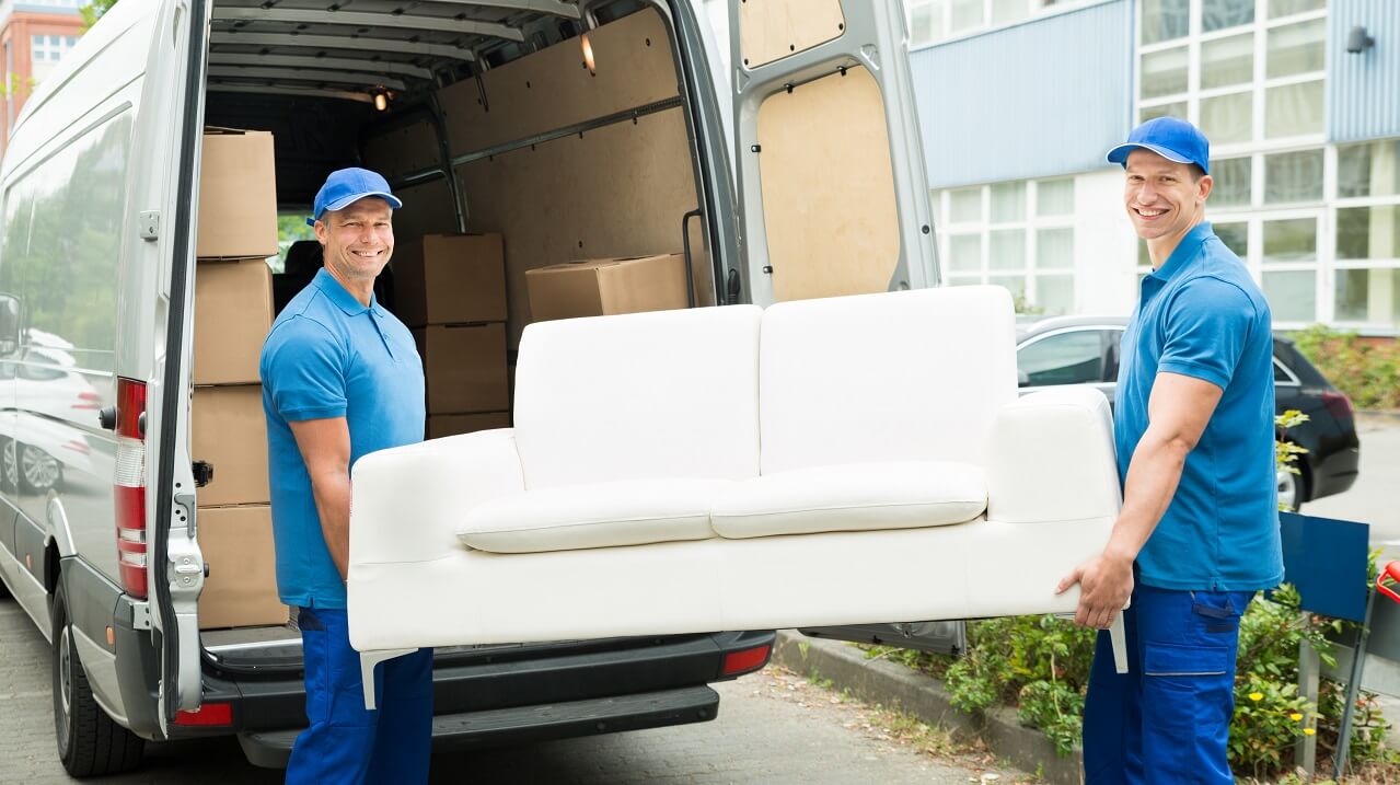 two movers with a sofa loading into the van