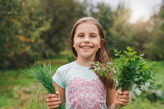 Girl holding non-poisonous plants/herbs outside