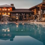 beautiful large home with pool at dusk with lights on