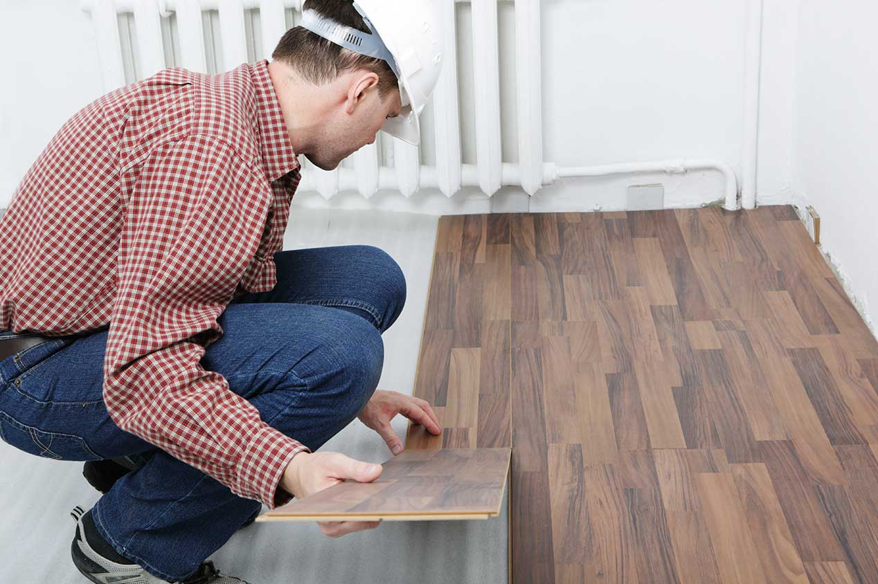 Person installing laminate flooring at home