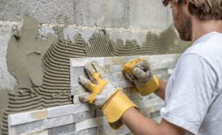 professional installs tile onto a wall